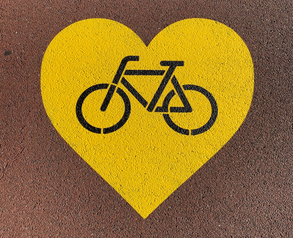 A yellow heart with a bicycle inside.